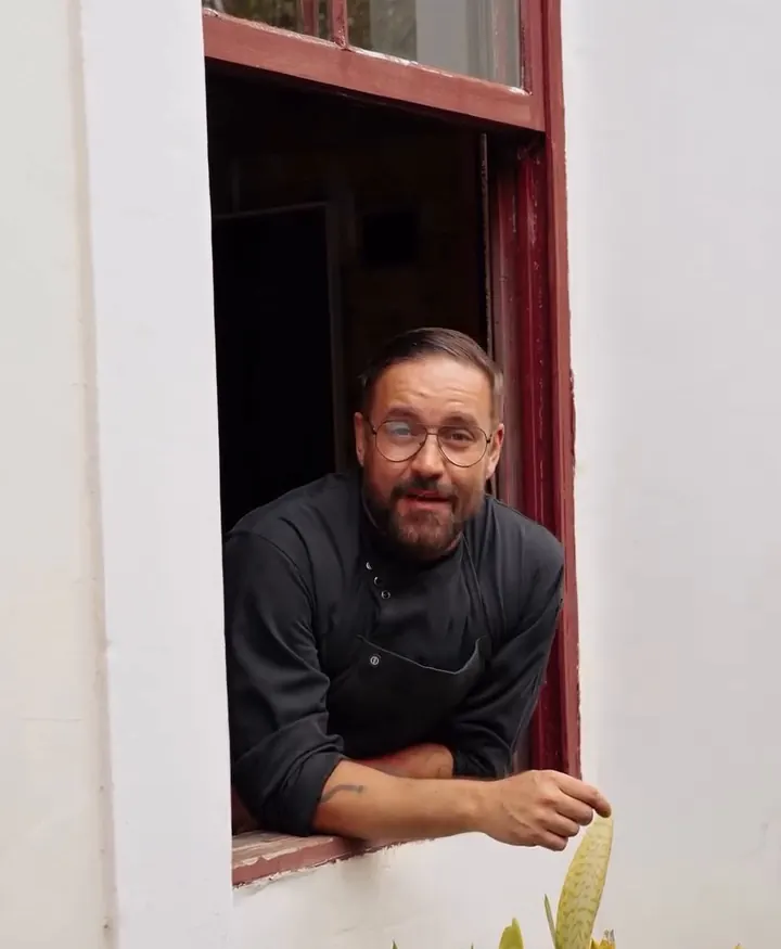 Chef Henrique na janela do casarão
