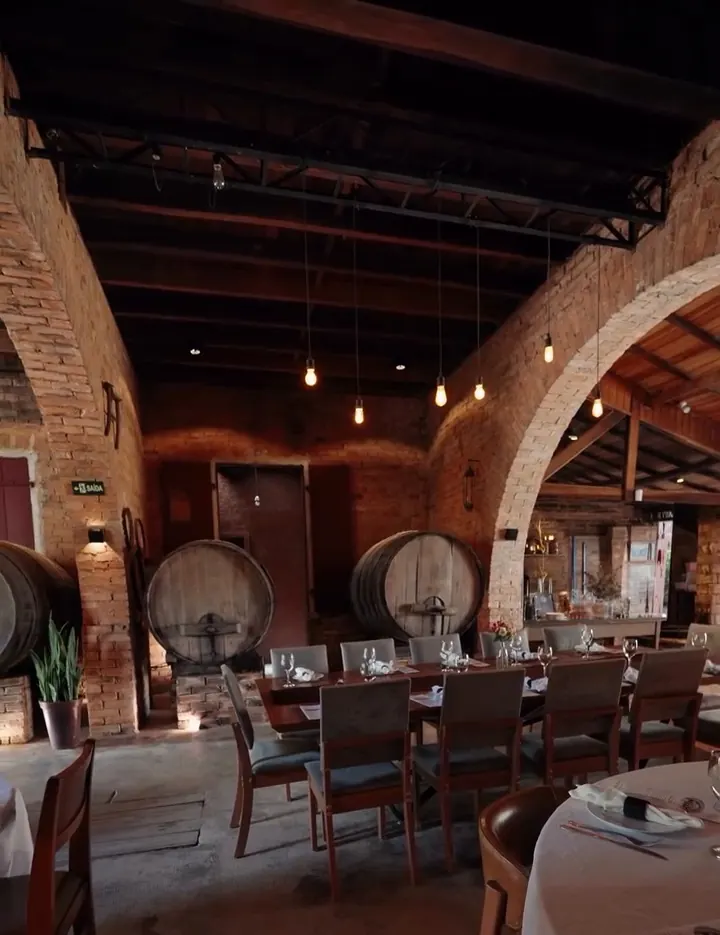 Antiga adega com arcos de tijolo e barris de vinho